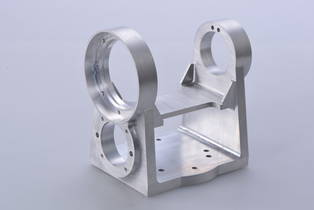 Machined metal bracket with circular bores, upright supports and a connecting base