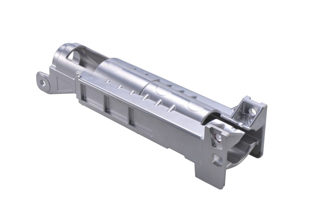 Elongated metal housing with thin sections, reinforcing ribs, bores and mounting lugs