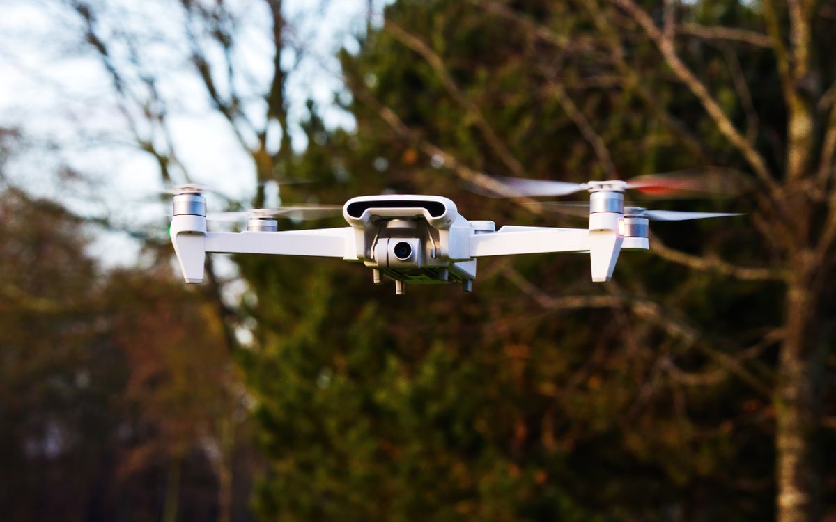 A quadcopter hovering outdoors